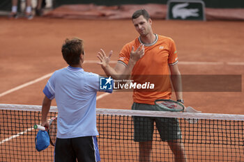 2024-05-26 - Winner Hubert Hurkacz of Poland shakes hands with Shintaro Mochizuki of Japan (left) during day 1 of the 2024 French Open, Roland-Garros 2024, Grand Slam tennis tournament on May 26, 2024 at Roland-Garros stadium in Paris, France - TENNIS - ROLAND GARROS 2024 - 26/05 - INTERNATIONALS - TENNIS