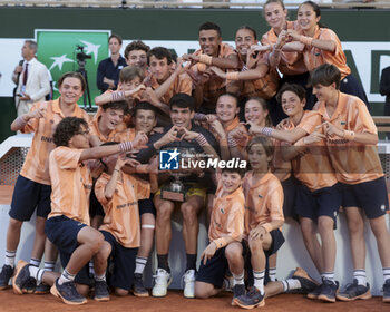 2024-06-09 - Winner Carlos Alcaraz of Spain poses with the ball kids following the men's final on day 15 of the 2024 French Open, Roland-Garros 2024, Grand Slam tennis tournament on June 9, 2024 at Roland-Garros stadium in Paris, France - TENNIS - ROLAND GARROS 2024 - 09/06 - INTERNATIONALS - TENNIS