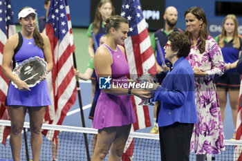 2024-09-08 - Winner Aryna Sabalenka of Belarus receives the trophy from Billie Jean King while finalist Jessica Pegula of USA (L) looks on during the podium ceremony of the women's final during day 13 of the 2024 US Open, Grand Slam tennis tournament on 7 September 2024 at USTA Billie Jean King National Tennis Center in New York, United States - TENNIS - US OPEN 2024 - 07/09 - INTERNATIONALS - TENNIS