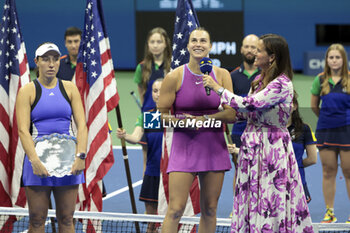 2024-09-08 - Winner Aryna Sabalenka of Belarus answers to Mary Joe Fernandez while finalist Jessica Pegula of USA (L) looks on during the podium ceremony of the women's final during day 13 of the 2024 US Open, Grand Slam tennis tournament on 7 September 2024 at USTA Billie Jean King National Tennis Center in New York, United States - TENNIS - US OPEN 2024 - 07/09 - INTERNATIONALS - TENNIS