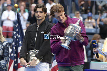 2024-09-08 - Winner Jannik Sinner of Italy celebrates while Taylor Fritz of USA (L) looks on during the trophy ceremony of the men's final on day 14 of the 2024 US Open, Grand Slam tennis tournament on September 8, 2024 at USTA Billie Jean King National Tennis Center in Flushing Meadows, Queens, New York, United States - TENNIS - US OPEN 2024 - 08/09 - INTERNATIONALS - TENNIS