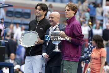 2024-09-08 - Finalist Taylor Fritz of USA, Andre Agassi, winner Jannik Sinner of Italy during the trophy ceremony of the men's final on day 14 of the 2024 US Open, Grand Slam tennis tournament on September 8, 2024 at USTA Billie Jean King National Tennis Center in Flushing Meadows, Queens, New York, United States - TENNIS - US OPEN 2024 - 08/09 - INTERNATIONALS - TENNIS