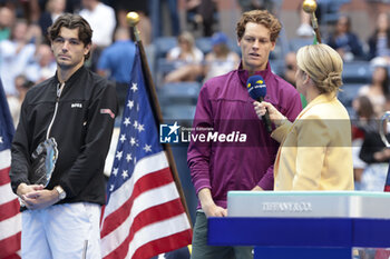 2024-09-08 - Winner Jannik Sinner of Italy is interviewed while finalist Taylor Fritz of USA (L) looks on during the trophy ceremony of the men's final on day 14 of the 2024 US Open, Grand Slam tennis tournament on September 8, 2024 at USTA Billie Jean King National Tennis Center in Flushing Meadows, Queens, New York, United States - TENNIS - US OPEN 2024 - 08/09 - INTERNATIONALS - TENNIS