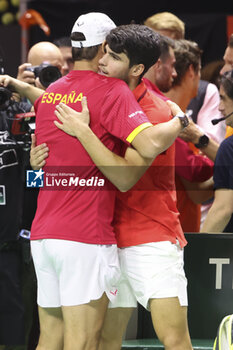 2024-11-20 - Rafael Nadal of Spain hugs Carlos Alcaraz after losing the tie after the 2024 Davis Cup Finals quarter-final tennis tie between Netherlands and Spain at Palacio de Deportes Jose Maria Martin Carpena on 19 November 2024 in Malaga, Spain - TENNIS - DAVIS CUP 2024 - 1/4 - NETHERLANDS V SPAIN - INTERNATIONALS - TENNIS