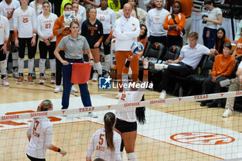 18/10/2024 - Texas libero Keonilei Akana (12) sets the ball as Texas head coach Jerritt Elliot looks on from behind the play - NCAA - TEXAS WOMEN VS ARKANSAS WOMEN - EVENTI - VOLLEY