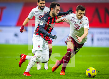 2021-01-12 - Hakan Calhanoglu of AC Milan fights for the ball against Alessandro Buongiorno of Torino FC - AC MILAN VS TORINO FC - ITALIAN CUP - SOCCER