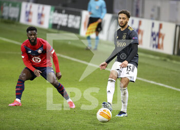 2021-02-18 - Devyne Rensch of Ajax, Jonathan Bamba of Lille (left) during the UEFA Europa League, round of 32, 1st leg football match between Lille OSC (LOSC) and AFC Ajax Amsterdam on February 18, 2021 at Stade Pierre Mauroy in Villeneuve-d'Ascq near Lille, France - Photo Jean Catuffe / DPPI - LILLE OSC (LOSC) AND AFC AJAX AMSTERDAM - UEFA EUROPA LEAGUE - SOCCER