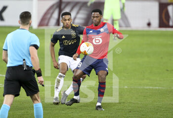 2021-02-18 - Jonathan David of Lille, Jurrien Timber of Ajax (left) during the UEFA Europa League, round of 32, 1st leg football match between Lille OSC (LOSC) and AFC Ajax Amsterdam on February 18, 2021 at Stade Pierre Mauroy in Villeneuve-d'Ascq near Lille, France - Photo Jean Catuffe / DPPI - LILLE OSC (LOSC) AND AFC AJAX AMSTERDAM - UEFA EUROPA LEAGUE - SOCCER