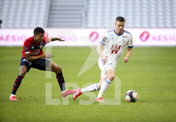 2021-02-28 - Frederic Guilbert of Strasbourg, Reinildo Mandava of Lille (left) during the French championship Ligue 1 football match between Lille OSC and RC Strasbourg on february 28, 2021 at Pierre Mauroy stadium in Villeneuve-d'Ascq near Lille, France - Photo Jean Catuffe / DPPI - LILLE OSC AND RC STRASBOURG - FRENCH LIGUE 1 - SOCCER