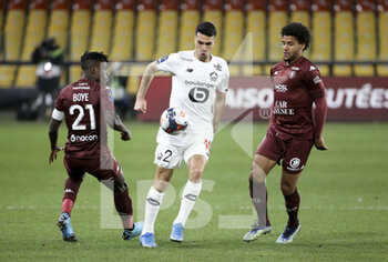 2021-04-09 - Mehmet Zeki Celik of Lille between John Boye and Dylan Bronn of FC Metz during the French championship Ligue 1 football match between FC Metz and Lille OSC (LOSC) on April 9, 2021 at Stade Saint-Symphorien in Metz, France - Photo Jean Catuffe / DPPI - FC METZ VS LILLE OSC (LOSC) - FRENCH LIGUE 1 - SOCCER