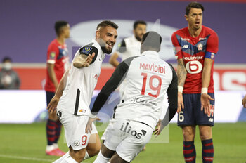 2021-04-16 - Andy Delort of Montpellier celebrates his goal with Stephy Mavididi of Montpellier while Jose Fonte of Lille looks on during the French championship Ligue 1 football match between LOSC and Montpellier HSC on April 16, 2021 at Pierre Mauroy stadium in Villeneuve-d'Ascq near Lille, France - Photo Jean Catuffe / DPPI - LOSC VS MONTPELLIER HSC - FRENCH LIGUE 1 - SOCCER
