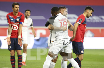 2021-04-16 - Andy Delort of Montpellier celebrates his goal with Stephy Mavididi of Montpellier while Jose Fonte of Lille (left) looks on during the French championship Ligue 1 football match between LOSC and Montpellier HSC on April 16, 2021 at Pierre Mauroy stadium in Villeneuve-d'Ascq near Lille, France - Photo Jean Catuffe / DPPI - LOSC VS MONTPELLIER HSC - FRENCH LIGUE 1 - SOCCER