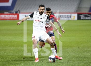 2021-04-16 - Gaetan Laborde of Montpellier, Reinildo Mandava of Lille during the French championship Ligue 1 football match between LOSC and Montpellier HSC on April 16, 2021 at Pierre Mauroy stadium in Villeneuve-d'Ascq near Lille, France - Photo Jean Catuffe / DPPI - LOSC VS MONTPELLIER HSC - FRENCH LIGUE 1 - SOCCER