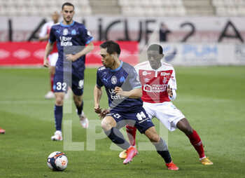 2021-04-23 - Yuto Nagatomo of Marseille, Fode Doucoure of Reims during the French championship Ligue 1 football match between Stade de Reims and Olympique de Marseille (OM) on April 23, 2021 at Stade Auguste Delaune in Reims, France - Photo Jean Catuffe / DPPI - STADE DE REIMS VS OLYMPIQUE DE MARSEILLE (OM) - FRENCH LIGUE 1 - SOCCER