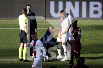 2021-04-24 - Kylian Mbappe of PSG is treated while Doctor of PSG Christophe Baudot and referee Willy Delajod look on during the French championship Ligue 1 football match between FC Metz and Paris Saint-Germain (PSG) on April 24, 2021 at Stade Saint-Symphorien in Metz, France - Photo Jean Catuffe / DPPI - FC METZ VS PARIS SAINT-GERMAIN (PSG) - FRENCH LIGUE 1 - SOCCER
