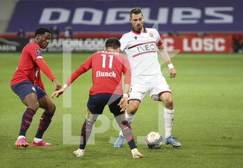 2021-05-01 - Morgan Schneiderlin of Nice, Jonathan David of Lille (left) during the French championship Ligue 1 football match between Lille OSC (LOSC) and OGC Nice (OGCN) on May 1, 2021 at Stade Pierre Mauroy in Villeneuve-d'Ascq near Lille, France - Photo Jean Catuffe / DPPI - LILLE OSC (LOSC) VS OGC NICE (OGCN) - FRENCH LIGUE 1 - SOCCER