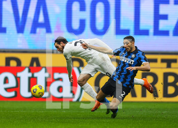 2020-12-20 - Achraf Hakimi of FC Internazionale fights for the ball against Simone Bastoni of Spezia Calcio during the Serie A 2020/21 football match between FC Internazionale vs Spezia Calcio at the San Siro Stadium, Milan, Italy on December 20, 2020 - Photo FCI / Fabrizio Carabelli - INTER VS SPEZIA - ITALIAN SERIE A - SOCCER