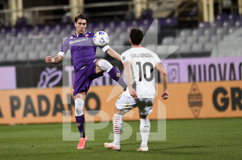 2021-03-21 - Dusan Vllahovic of ACF Fiorentina in action against Hakan Calhanoglu of AC Milan  - ACF FIORENTINA VS AC MILAN - ITALIAN SERIE A - SOCCER