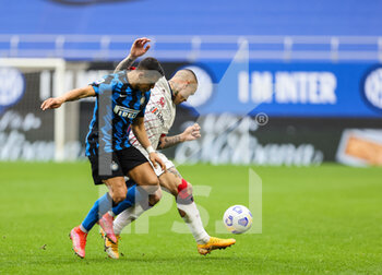 2021-04-11 - Radja Nainggolan of Cagliari Calcio fights for the ball against Alexis Sanchez of FC Internazionale during the Serie A 2020/21 football match between FC Internazionale vs Cagliari Calcio at the Giuseppe Meazza Stadium, Milan, Italy on April 11, 2021 - Photo FCI / Fabrizio Carabelli - INTER - FC INTERNAZIONALE VS CAGLIARI CALCIO - ITALIAN SERIE A - SOCCER