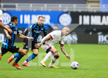 2021-04-11 - Radja Nainggolan of Cagliari Calcio fights for the ball against Alexis Sanchez of FC Internazionale and Christian Eriksen of FC Internazionale during the Serie A 2020/21 football match between FC Internazionale vs Cagliari Calcio at the Giuseppe Meazza Stadium, Milan, Italy on April 11, 2021 - Photo FCI / Fabrizio Carabelli - INTER - FC INTERNAZIONALE VS CAGLIARI CALCIO - ITALIAN SERIE A - SOCCER