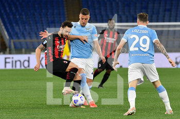 2021-04-26 - Hakan Calhanoglu of AC Milan and Sergej Milinkovic-Savic of SS Lazio seen in action during the Italian Football Championship League A 2020/2021 match between SS Lazio vs AC Milan at the Olimpic Stadium in Rome. - SS LAZIO VS AC MILAN - ITALIAN SERIE A - SOCCER