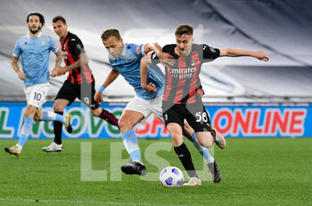 2021-04-26 - Alexis Saelemaekers of AC Milan and Lucas Leiva of SS Lazio seen in action during the Italian Football Championship League A 2020/2021 match between SS Lazio vs AC Milan at the Olimpic Stadium in Rome. - SS LAZIO VS AC MILAN - ITALIAN SERIE A - SOCCER