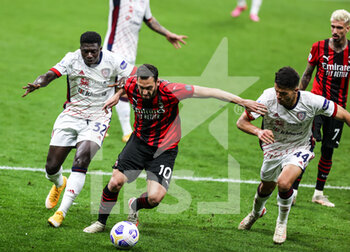2021-05-16 - Hakan Calhanoglu of AC Milan fights for the ball against Alfred Duncan of Cagliari Calcio and Andrea Carboni of Cagliari Calcio during the Serie A 2020/21 football match between AC Milan vs Cagliari Calcio at Giuseppe Meazza Stadium, Milan, Italy on May 16, 2021 - Photo FCI / Fabrizio Carabelli - AC MILAN VS CAGLIARI CALCIO - ITALIAN SERIE A - SOCCER