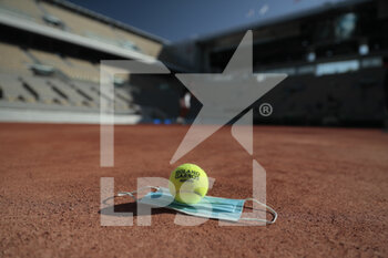 2020-09-21 - Illustration of official tennis ball Roland Garros 2020 by Wilson on the clay of Philippe Chatrier court over protector mask under the CoVid health crisis 19 during the Roland Garros 2020, Grand Slam tennis tournament, Qualifying, on September 21, 2020 at Roland Garros stadium in Paris, France - Photo Stephane Allaman / DPPI - ROLAND GARROS 2020, GRAND SLAM - QUALIFYING - INTERNATIONALS - TENNIS