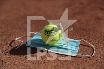 2020-09-21 - Illustration of official tennis ball Roland Garros 2020 by Wilson on the clay of Philippe Chatrier court over protector mask with swab sample with tube of physiological liquid under the CoVid health crisis 19 during the Roland Garros 2020, Grand Slam tennis tournament, Qualifying, on September 21, 2020 at Roland Garros stadium in Paris, France - Photo Stephane Allaman / DPPI - ROLAND GARROS 2020, GRAND SLAM - QUALIFYING - INTERNATIONALS - TENNIS
