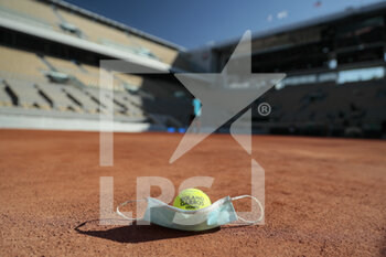 2020-09-21 - Illustration of official tennis ball Roland Garros 2020 by Wilson over protector mask on clay of Philippe Chatrier court under the CoVid health crisis 19 during the Roland Garros 2020, Grand Slam tennis tournament, Qualifying, on September 21, 2020 at Roland Garros stadium in Paris, France - Photo Stephane Allaman / DPPI - ROLAND GARROS 2020, GRAND SLAM - QUALIFYING - INTERNATIONALS - TENNIS