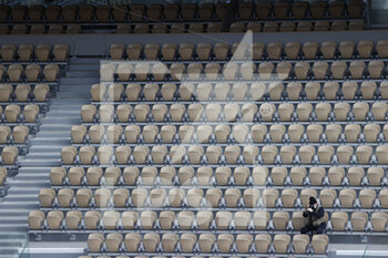2020-10-05 - Alone photographer isolated among the empty seats around is dressed as in winter equipped with caps, scarves, jackets, folded up on themselves seized by the cold and wet wind on Philippe Chatrier stadium during the Roland Garros 2020, Grand Slam tennis tournament, on October 5, 2020 at Roland Garros stadium in Paris, France - Photo Stephane Allaman / DPPI - ROLAND GARROS 2020, GRAND SLAM TOURNAMENT - INTERNATIONALS - TENNIS
