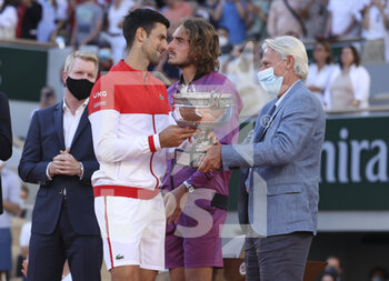 2021-06-13 - Winner Novak Djokovic of Serbia receives the trophy from Bjorn Borg while Jim Courier and finalist Stefanos Tsitsipas of Greece look on during the trophy ceremony of the men's final on day 15 of Roland-Garros 2021, French Open 2021, a Grand Slam tennis tournament on June 13, 2021 at Roland-Garros stadium in Paris, France - Photo Jean Catuffe / DPPI - ROLAND-GARROS 2021, FRENCH OPEN 2021, A GRAND SLAM TENNIS TOURNAMENT - INTERNATIONALS - TENNIS